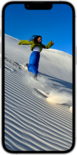 Pantalla Super Retina XDR de un iPhone 16e que muestra a varias personas caminando por una duna de arena